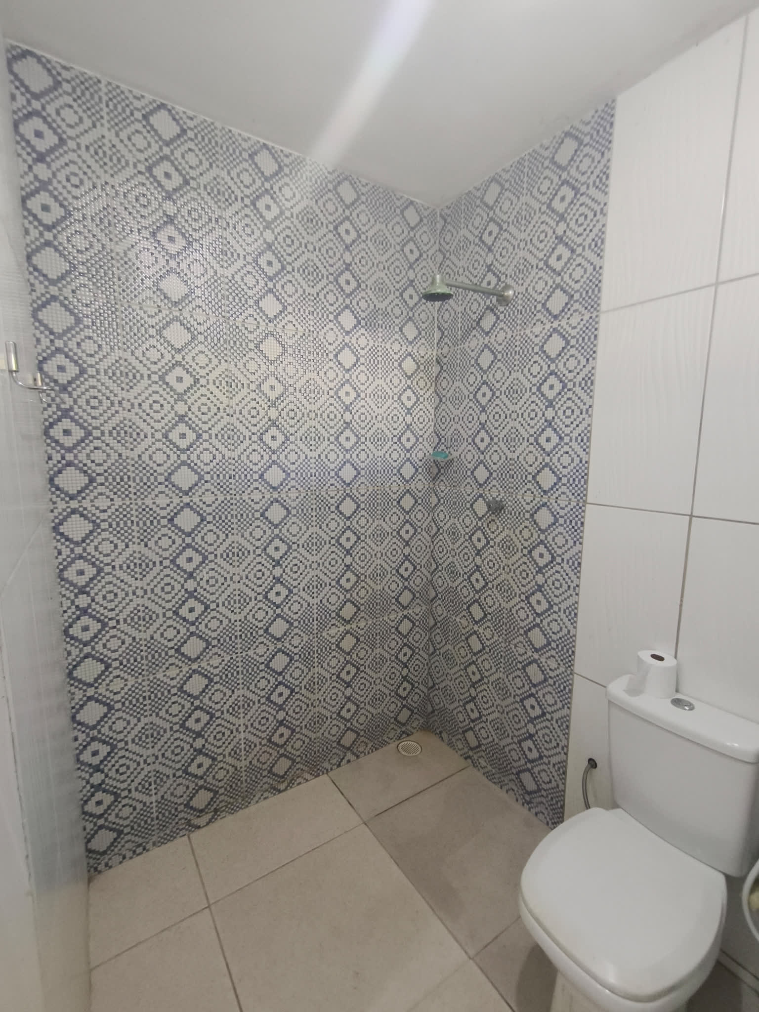Banheiro com chuveiro e azulejos decorativos em tons de azul no Studio29