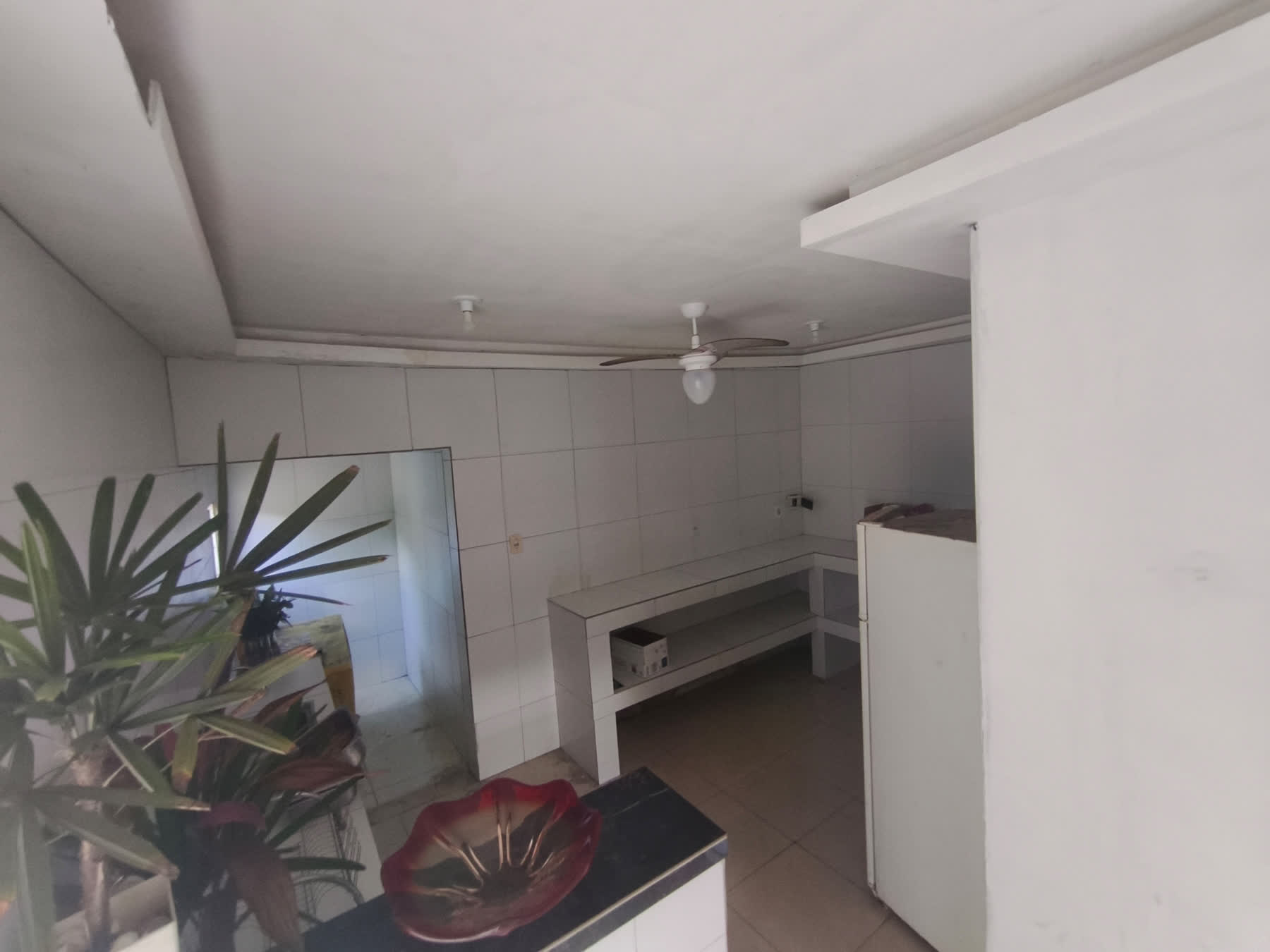 Área interna de serviço do Studio29 com bancadas de apoio e geladeira