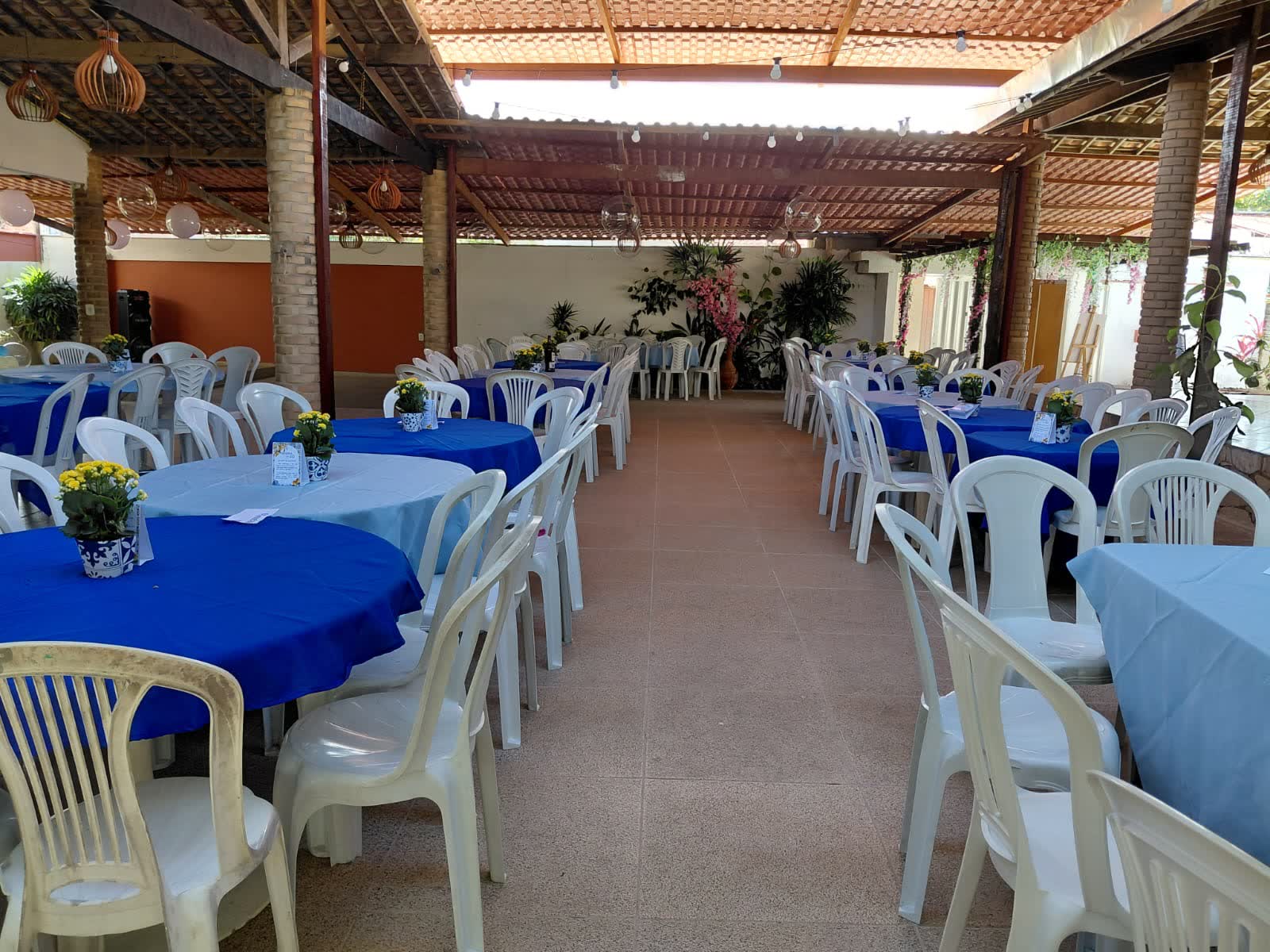 Evento montado no Studio29 com mesas redondas de toalha azul e cadeiras brancas