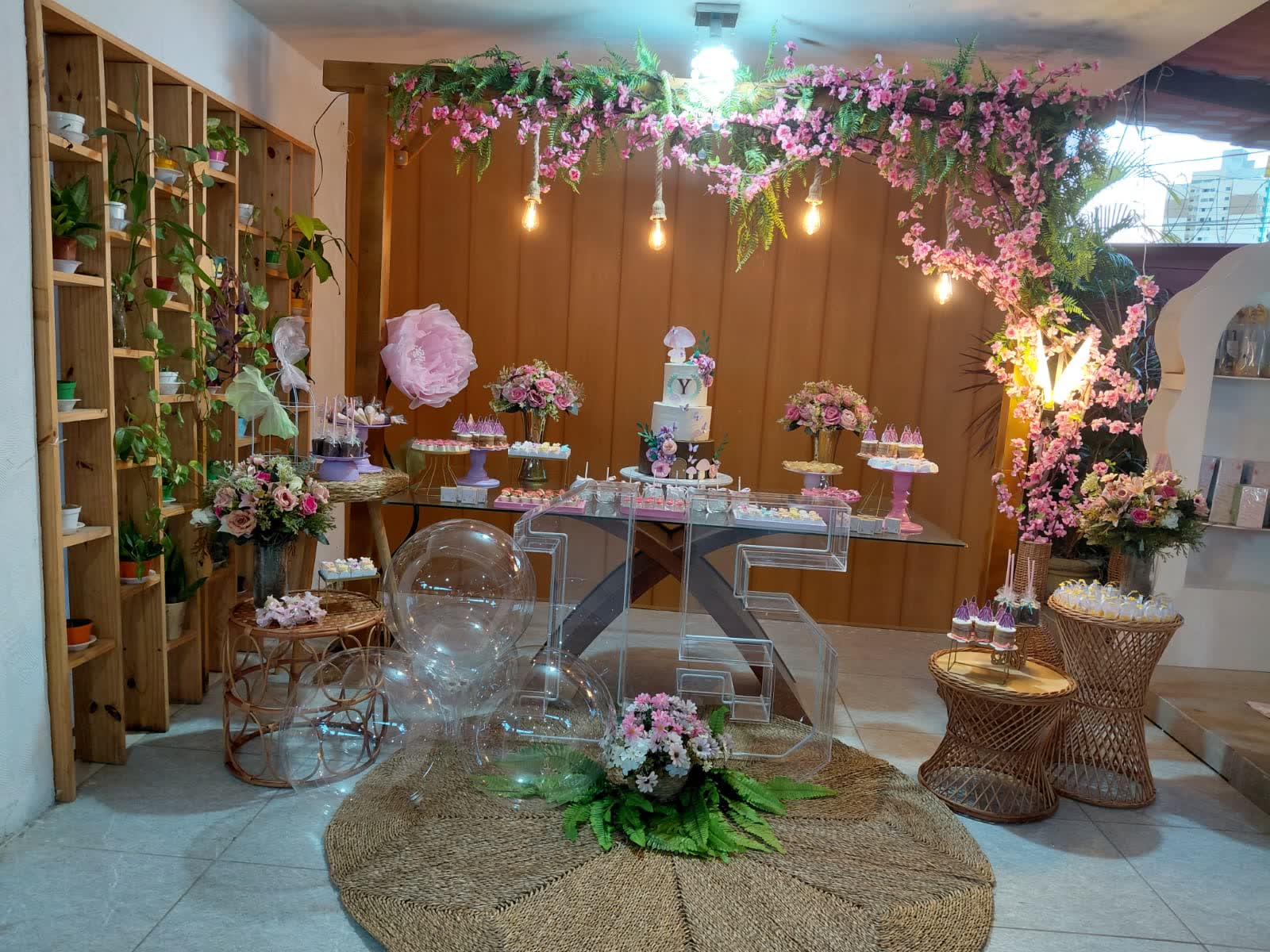 Mesa de bolo de 15 anos no Studio29 com flores rosas e iluminação pendente